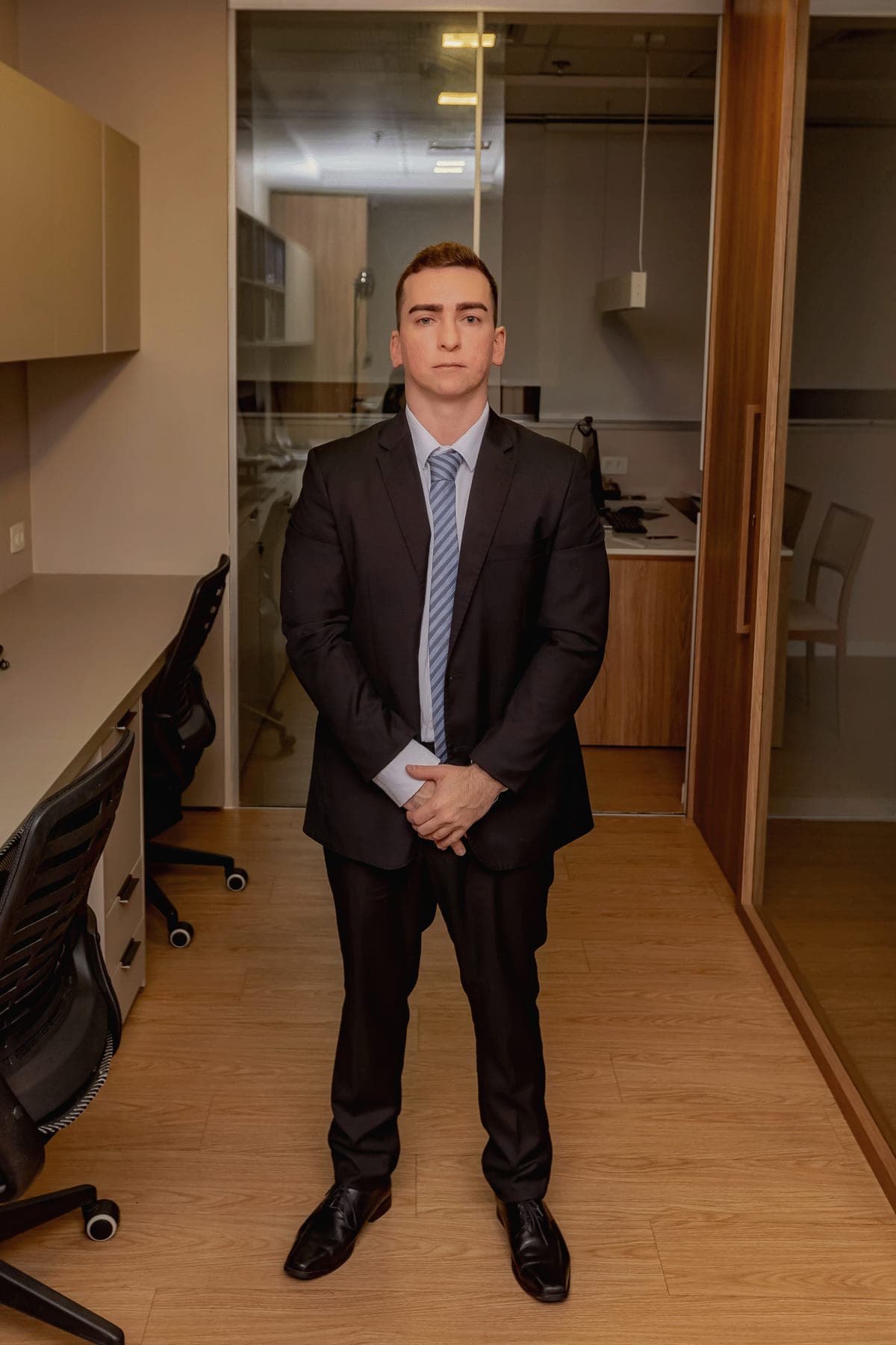Dr. Daniel Sá Hage Calabrich em pé no corredor do escritório Hage Calabrich